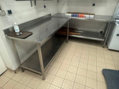 a kitchen with a stainless steel counter and a refrigerator
