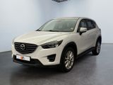 a white mazda cx - 5 parked in a showroom
