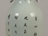 a white vase with asian writing on it on a table
