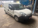 La camionnette blanche est garée dans le garage, devant d'autres véhicules.