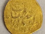 a close up of a gold coin on a white surface
