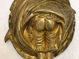 gold plated wall sconce with a woman holding a baby