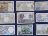 several different bank notes are arranged on a blue surface