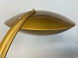 brass plated table lamp with a curved arm and a metal base