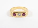 a yellow gold ring with three ruby stones and a diamond