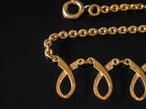 a close up of a gold chain with a knot on it