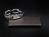 a close up of a silver bracelet with a tag on it