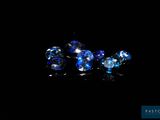 three blue and white glass beads sitting on top of a black surface