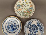 trois assiettes bleues et blanches ornées de motifs floraux, posées sur une table