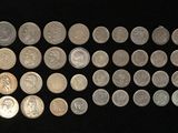 a lot of silver coins on a black surface