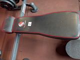 a gym bench with a pair of dumbbells on it