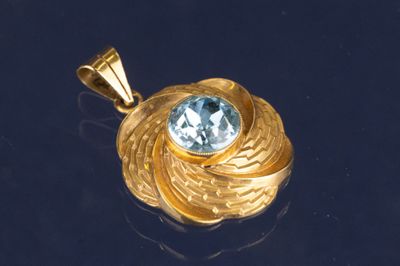 une image représentant un pendentif en or orné d'une topaze bleue