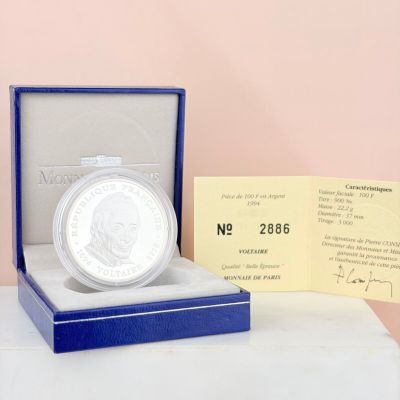 a silver coin sitting in a blue box on a table