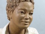 a statue of a young boy holding a tennis racquet