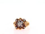a close up of a gold ring with a diamond center