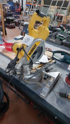 une scie circulaire jaune et noire posée sur une table dans un atelier