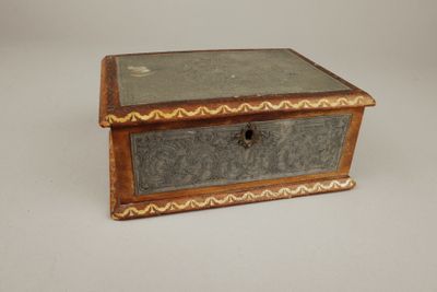 une vieille boîte en bois posée sur une surface blanche