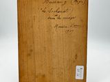 an old wooden box with writing on it sitting on a white surface