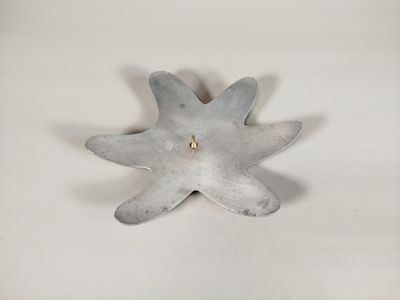 un petit objet métallique posé sur une surface blanche
