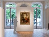 a man standing in a room with a painting on the wall