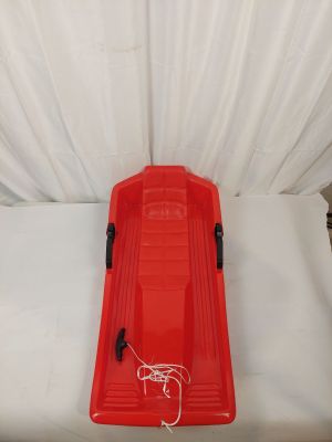 a red sled sitting on top of a white bed