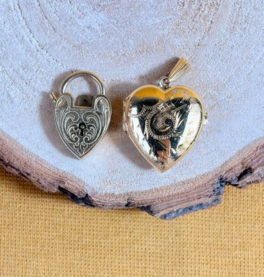 deux cadenas argentés en forme de cœur posés sur un morceau de bois