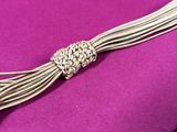 a close up of a silver plated necklace on a purple cloth