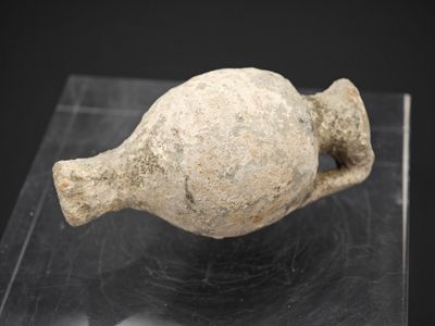 un objet en pierre exposé sur une surface noire