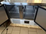a small refrigerator with two doors open in a kitchen