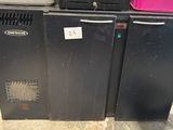 three black refrigerators are stacked on top of each other in a warehouse