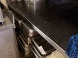 stainless steel counter top in a commercial kitchen with pots and pans on it