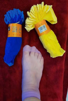 a person ' s feet on a towel next to a pair of socks and a pair of socks
