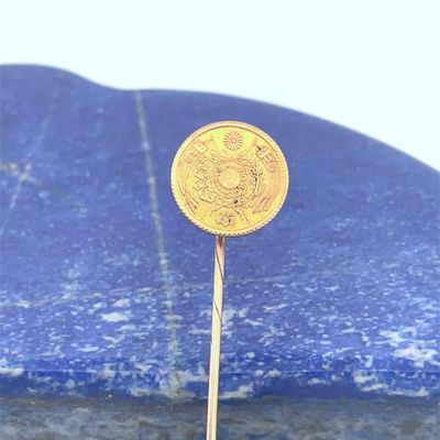 une pièce d'or posée sur une pierre bleue