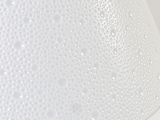a close up of a white lamp shade on a table