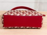 a small red purse sitting on top of a wooden table