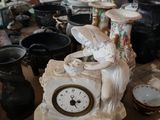 une table sur laquelle se trouvent une horloge, des vases et d'autres objets