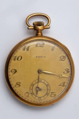 a close up of a gold pocket watch on a white surface