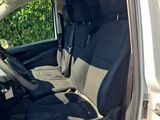 the interior of a white van with black seats and a steering wheel