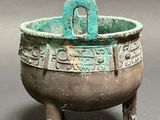 a close up of a metal bowl with a handle