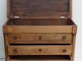 a small wooden chest with three drawers on it
