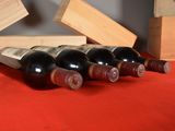 several bottles of wine are lined up on a red table