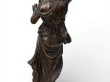 a bronze statue of a woman holding a flower in her hand