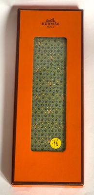 an orange box with a green tie sitting on top of a white table