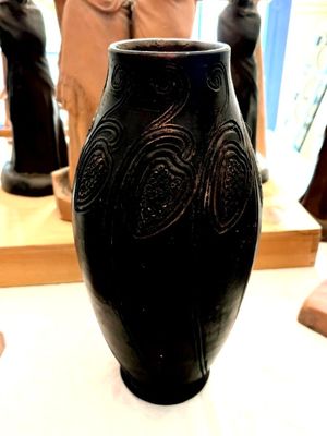 un vase noir posé sur une table dans une pièce