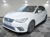 la voiture blanche est garée sur un sol en damier dans le garage