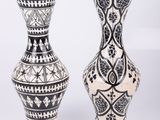 une paire de vases noir et blanc ornés de motifs sur fond blanc