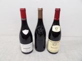 three bottles of wine that are sitting on a table