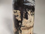 a black bottle with a brown lid sitting on a table