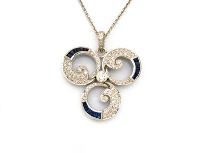 une photo d'un pendentif en diamant et saphir monté sur une chaîne