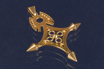 une image représentant un pendentif en or sur un fond noir